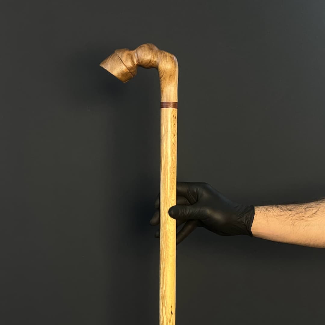 نمای نزدیک از دسته پیکری شکل عصا با بافت طبیعی چوب گردو