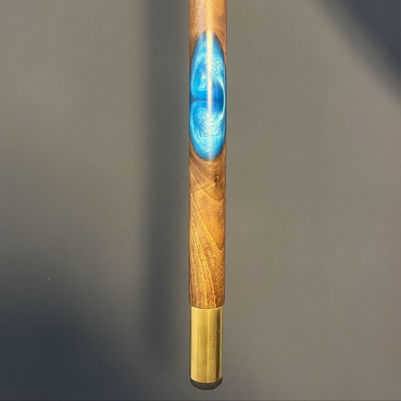 نمای نزدیک از تزئینات رزینی آبی‌رنگ روی بدنه عصا آبتین