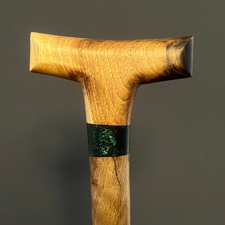 حلقه رزینی سبزرنگ روی بدنهی چوبی عصا آرین