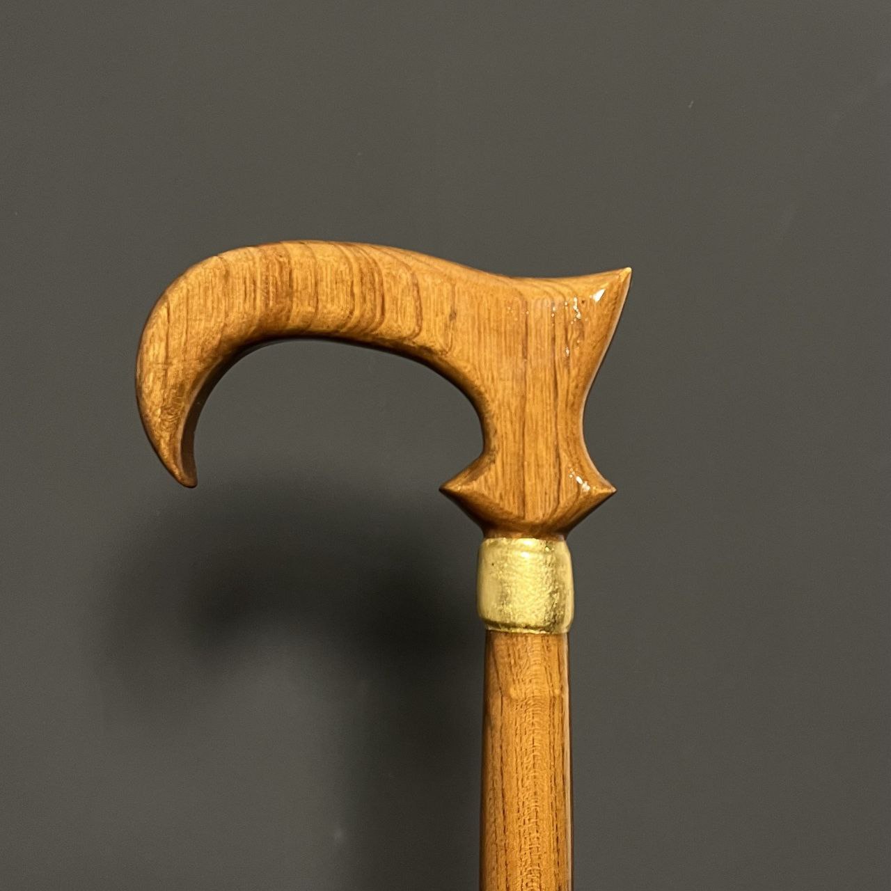 نمای نزدیک از عصا مدل کارا با چوب آزاد خوش‌رگه و طراحی خاص دسته برای راحتی دست