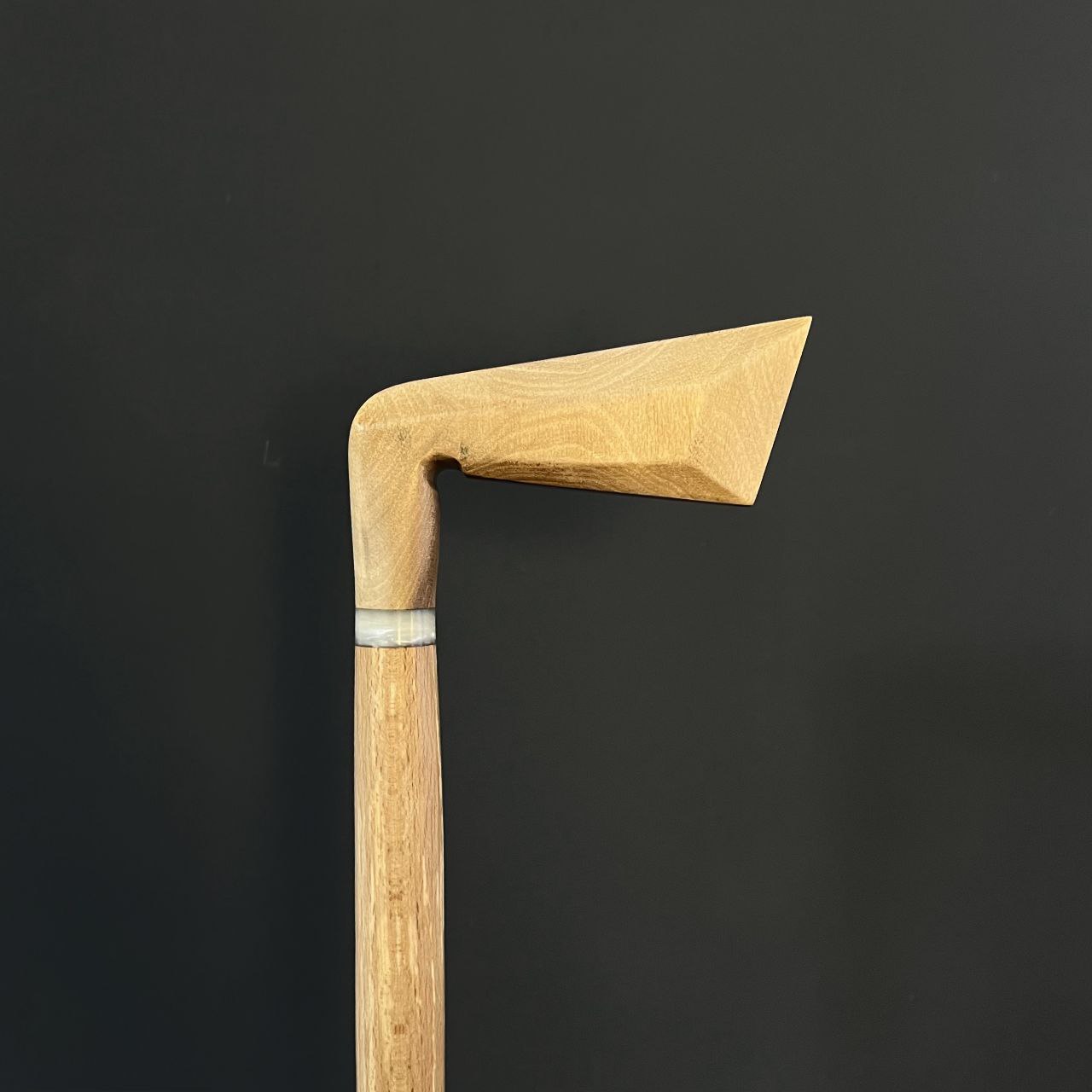 نمای نزدیک از زاویه دسته عصای طرح چوب گلف با طراحی خاص و الهام‌گرفته از چوبدست گلف‌بازان، ساخته شده از چوب گردو گیلان