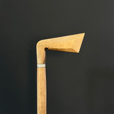 نمای نزدیک از زاویه دسته عصای طرح چوب گلف با طراحی خاص و الهامگرفته از چوبدست گلفبازان، ساخته شده از چوب گردو گیلان