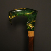 نمای نزدیک از دسته رزینی سبز شفاف عصا مدل زمردین، شبیه سنگ قیمتی زمرد.