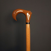 نمای نزدیک دسته ارگونومیک عصا دیبا، چوب گردوی گیلان با پرداخت کهربایی براق و حلقهٔ رزینی مشکی