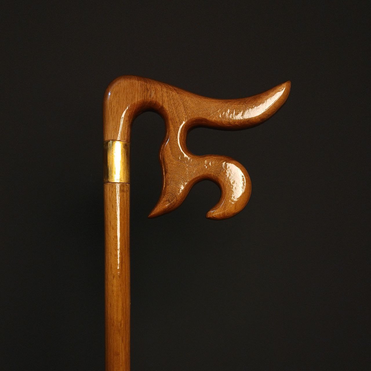 نمای نزدیک دسته؛ منبت نام «علی» روی چوب گردوی گیلان، پرداخت جلا و پتینهٔ طلایی