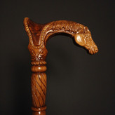 عکس نزدیک از دستهی منبتکاریشده عصا مدل رخش — سر اسب منبتشده روی چوب راش، پرداخت کهربایی براق.